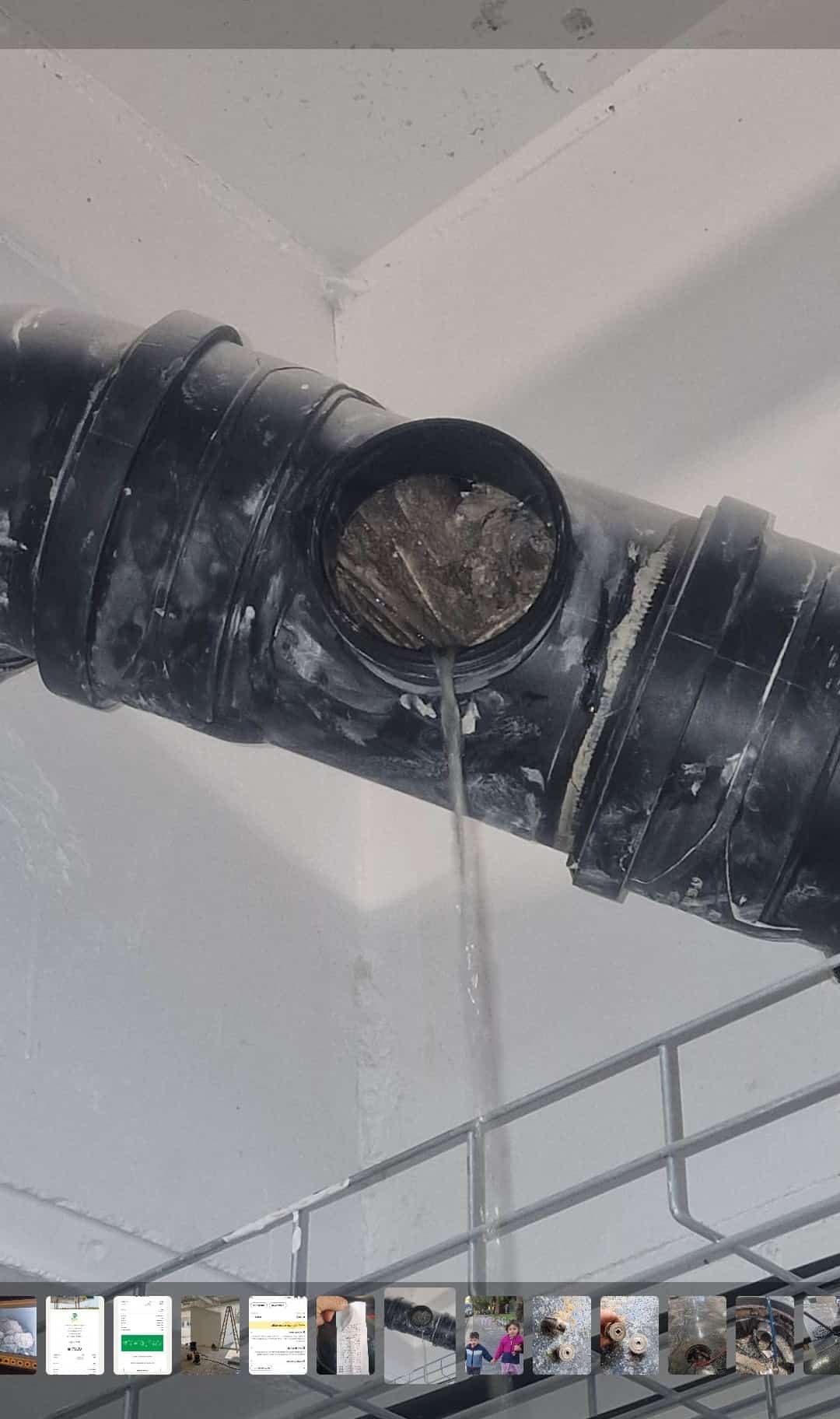 פתח ביקורת פתוח בצינור ביוב שחור מתחת לתקרה ובתוכו סתימה